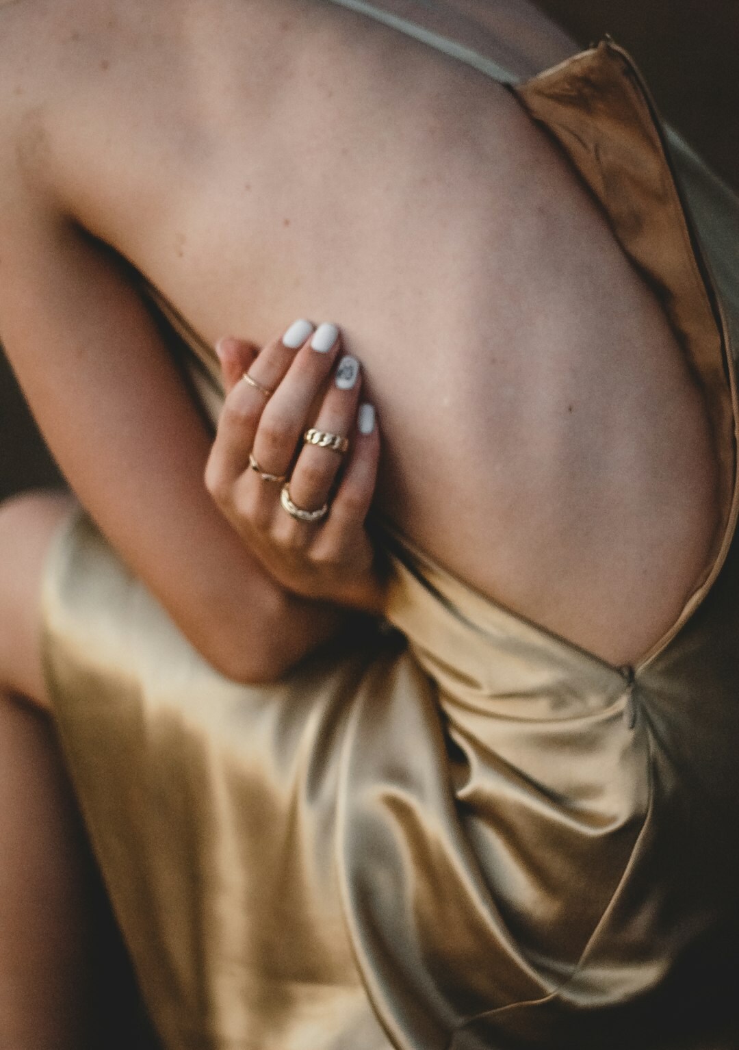 Close-up texture of silk fabric and gold jewelry detail