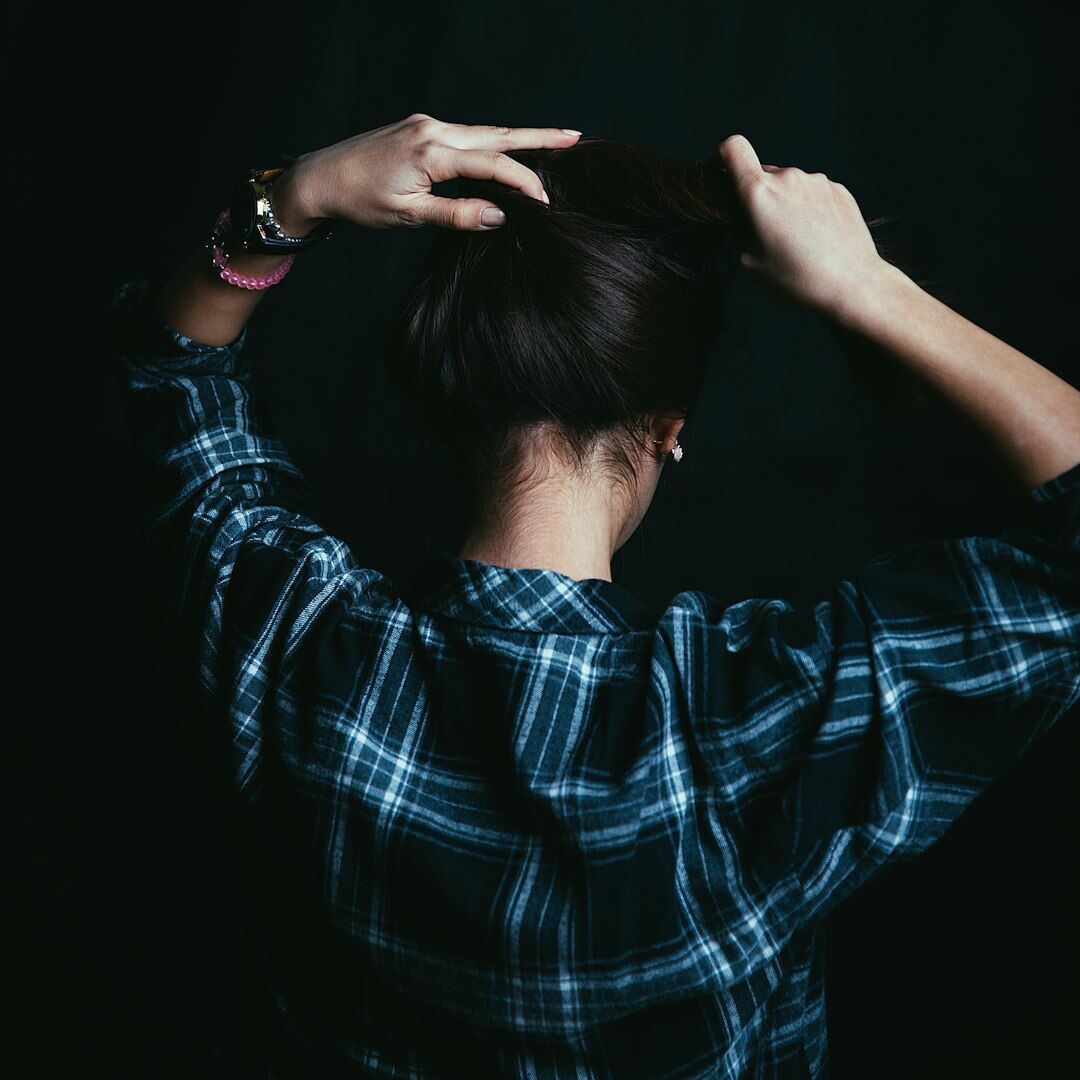 Stylist adjusting a model's hair backstage before a fashion show