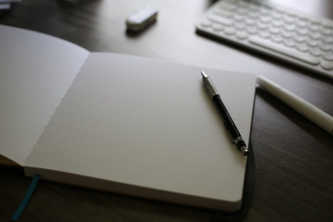 Open notebook with handwritten notes and a pen on a wooden table